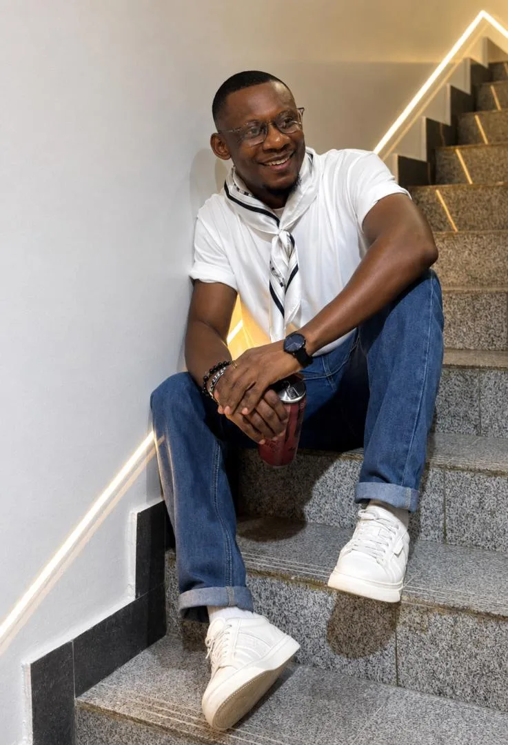 j BOLD seated on a staircase